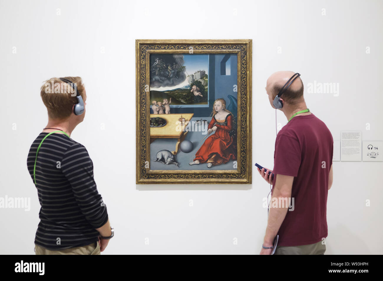 Visitors use audio guides in front of the painting 'Melancholy' by