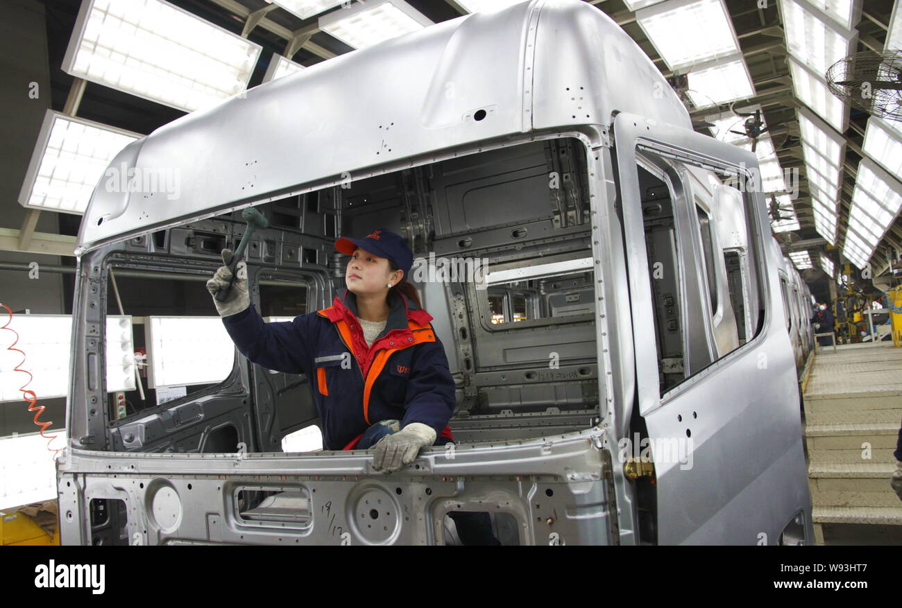 --FILE--A female Chinese worker checks a truck on the assembly line at ...