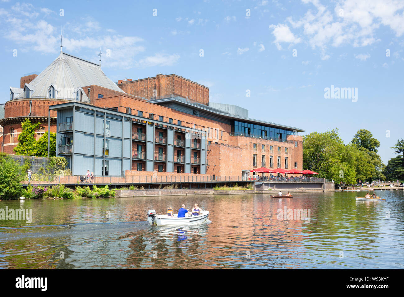 Small boat passing the RSC theatre Royal Shakespeare company theatre beside the River Avon Stratford upon avon Warwickshire England UK GB EU Europe Stock Photo