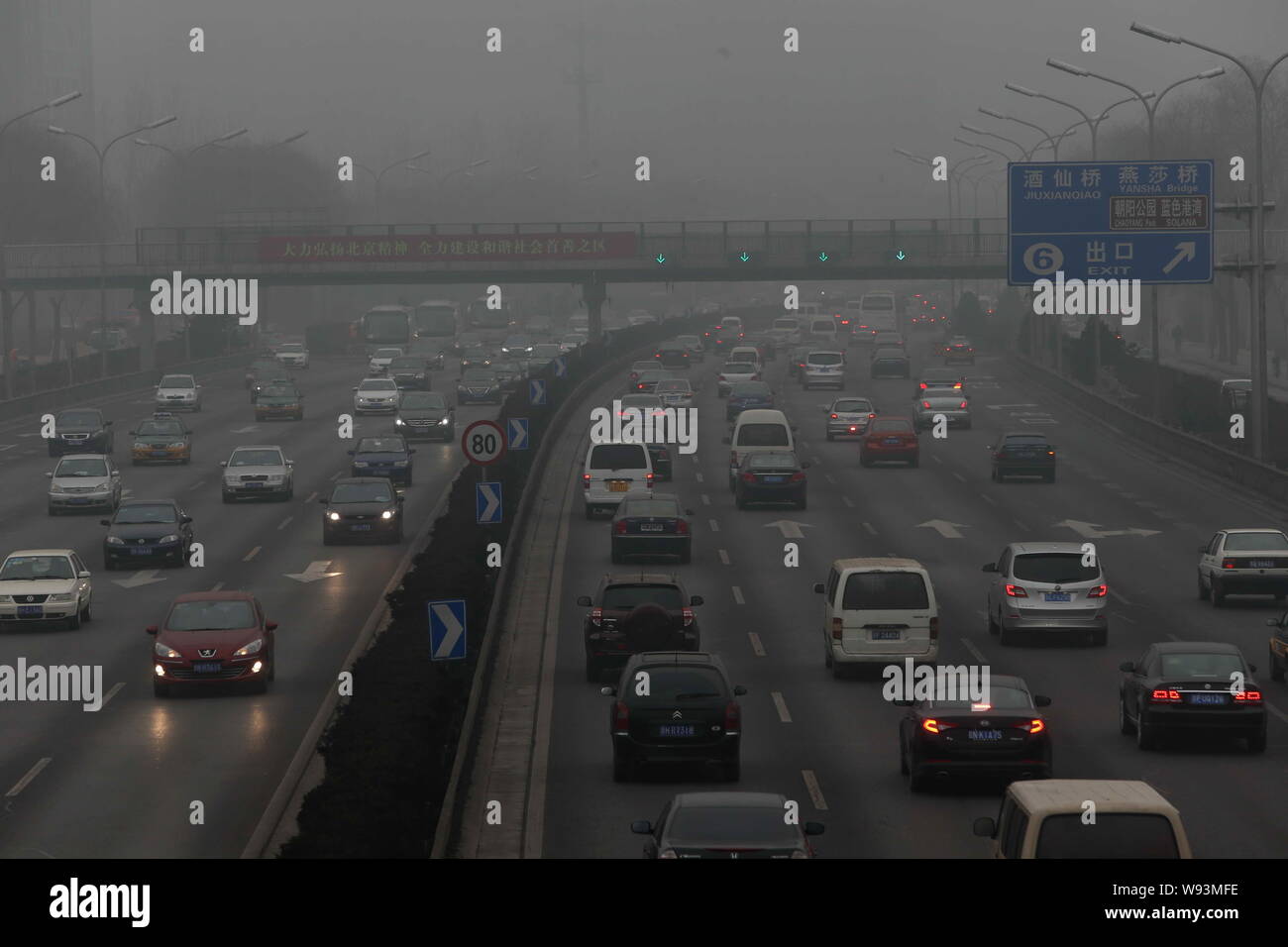 Cars travel on a road in heavy smog in Beijing, China, 30 January 2013.   Endless lines of slow-moving cars emerge like apparitions and then disappear Stock Photo