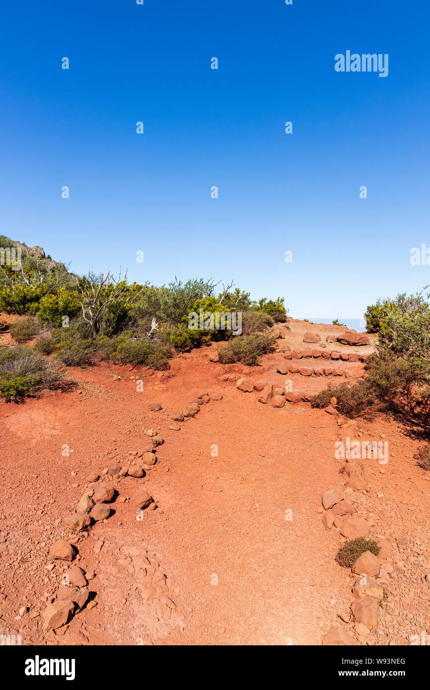 Walking trail over red soil at the ridge, between Santiago del Teide and Masca, Tenerife, Canary Islands, Spain Stock Photo