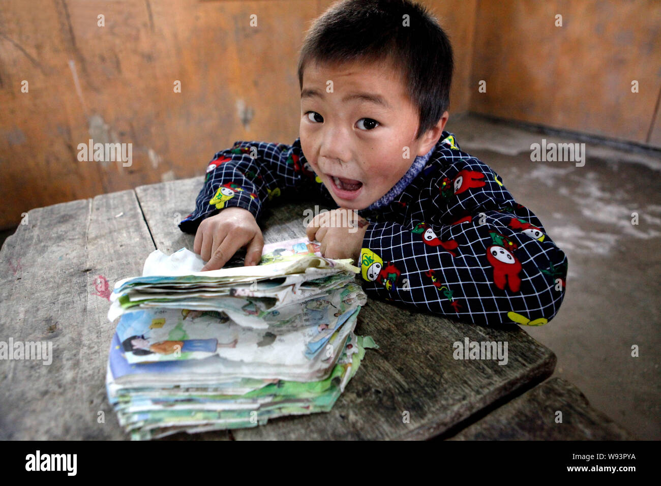 --FILE--A young Chinese student reads his textbook in a shabby classroom at Baigedang Primary School in Daping village, Songxian county, Luoyang city, Stock Photo