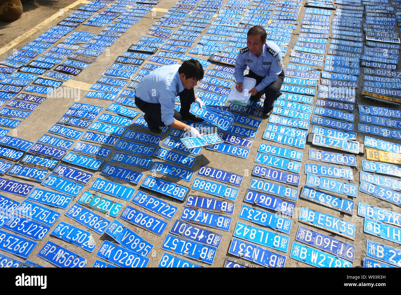 Chinese police officers check and register unclaimed car plates which were washed away by heavy rains caused by Typhoon Fitow at a branch of traffic p Stock Photo