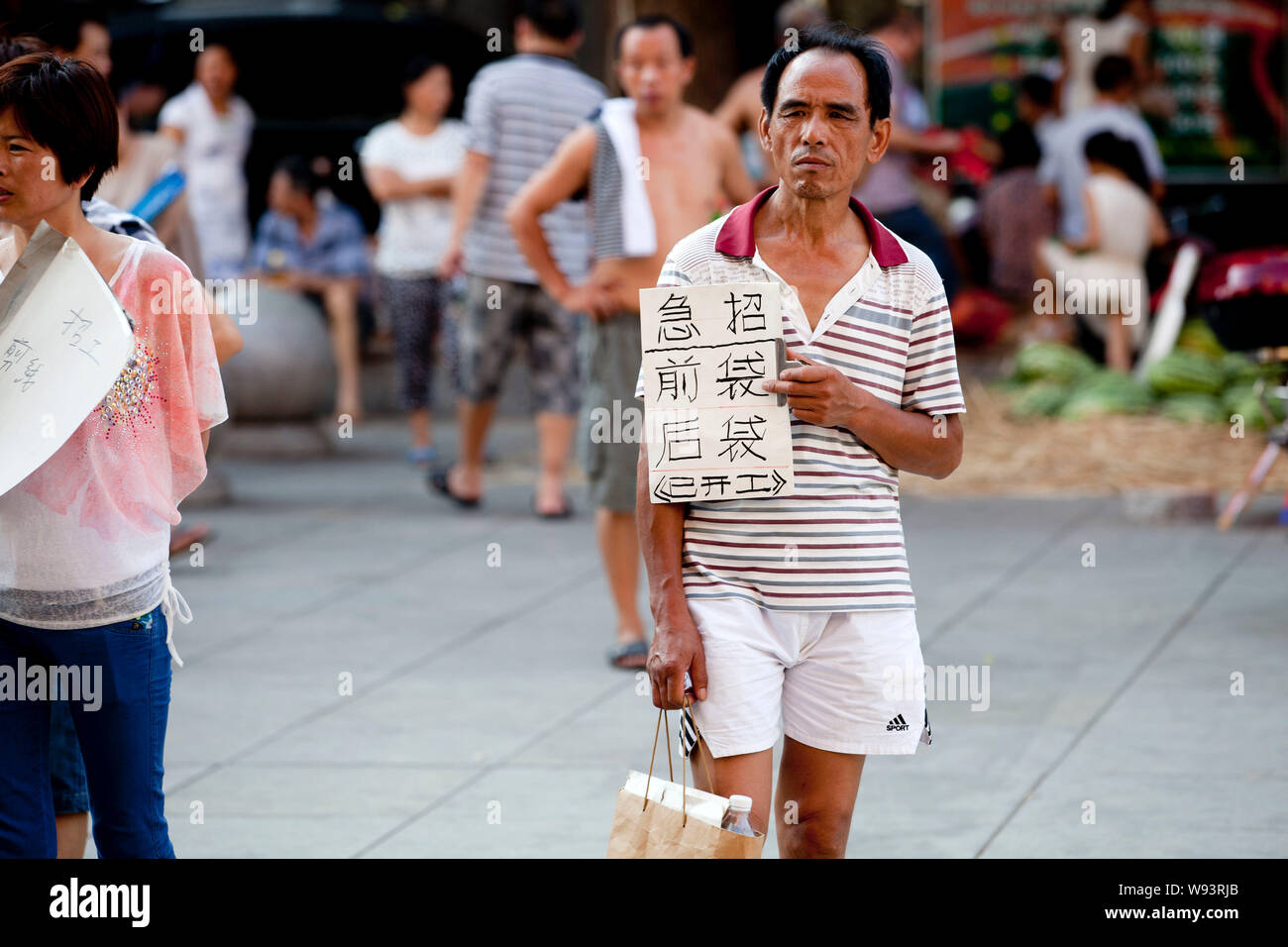 Chinese recruiters hold placards showing information of jobs offered by