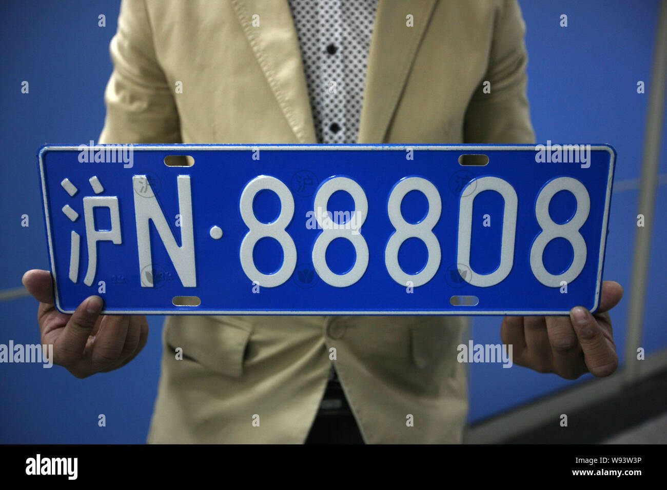 A Chinese car owner shows a pre-owned car license plate with lucky numbers he bought at a second-hand automobile trade center in Shanghai, China, 25 M Stock Photo