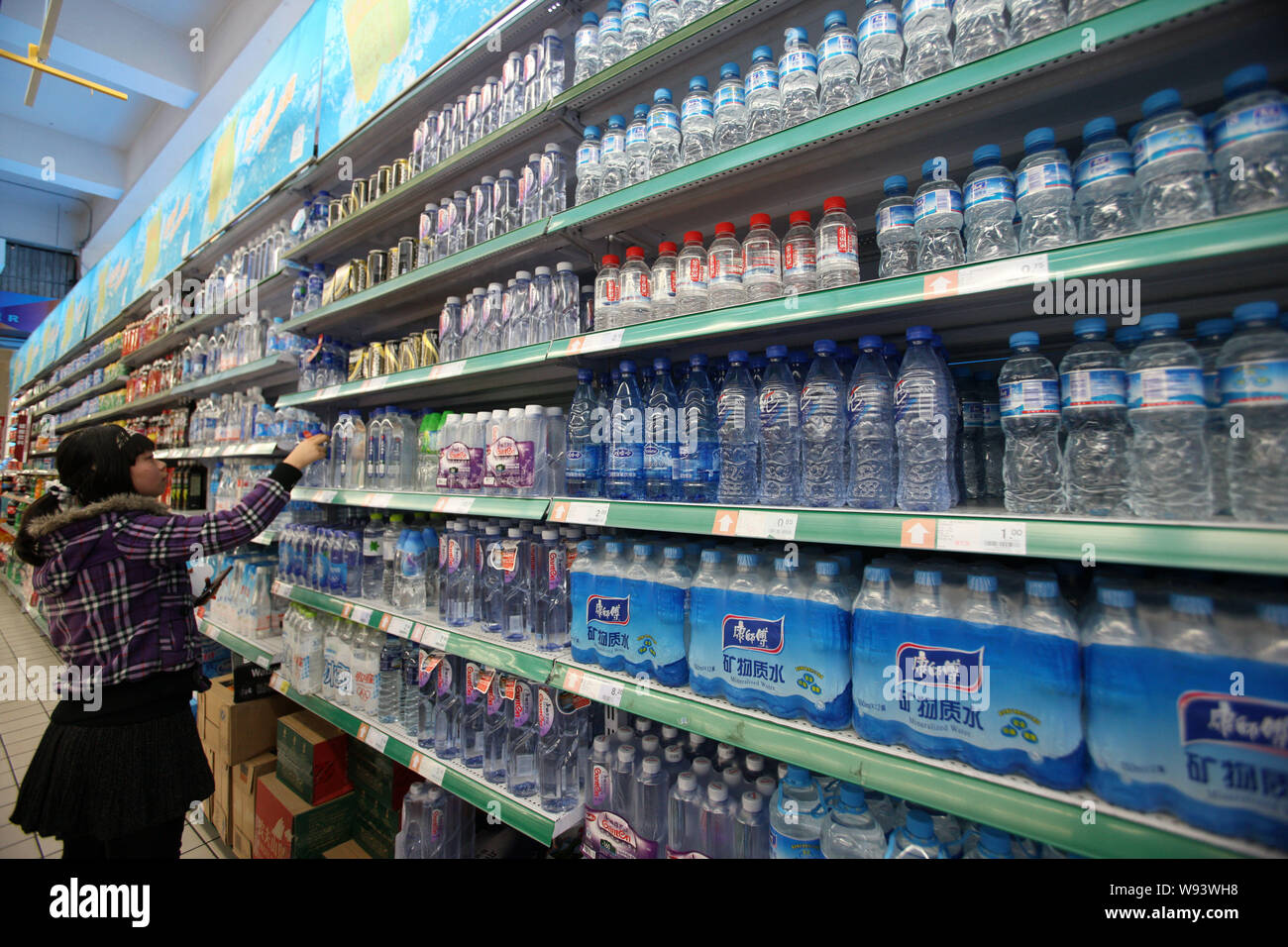 A customer selects bottled water at a mall in Shanghai, China, 28 January 2013.     Water quality is a big concern for Chinese consumers. They are tur Stock Photo
