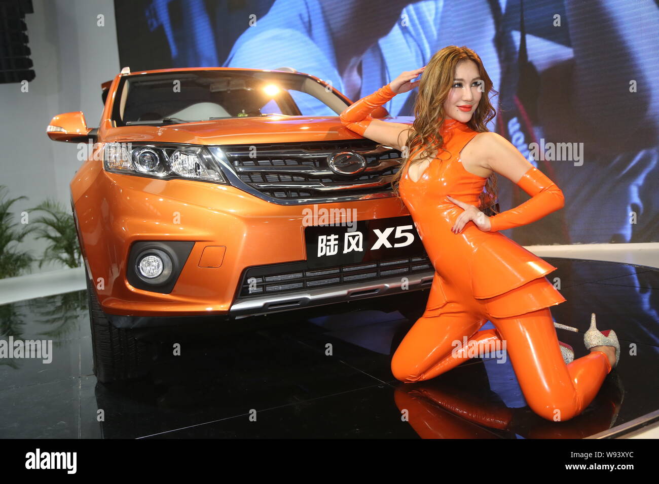A model poses with a Landwind X5 during the 11th China (Guangzhou) International Automobile Exhibition, known as Auto Guangzhou 2013, in Guangzhou cit Stock Photo