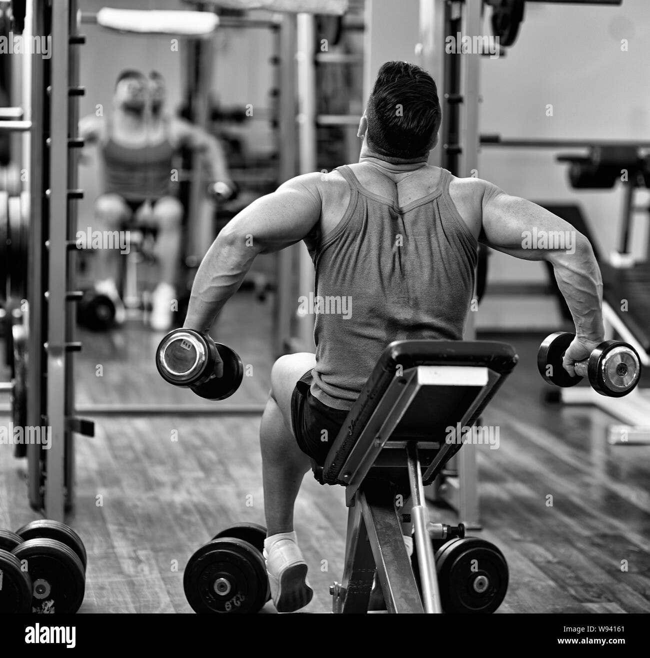 Man Doing Shoulders And Back Workout In Front Of The Mirror