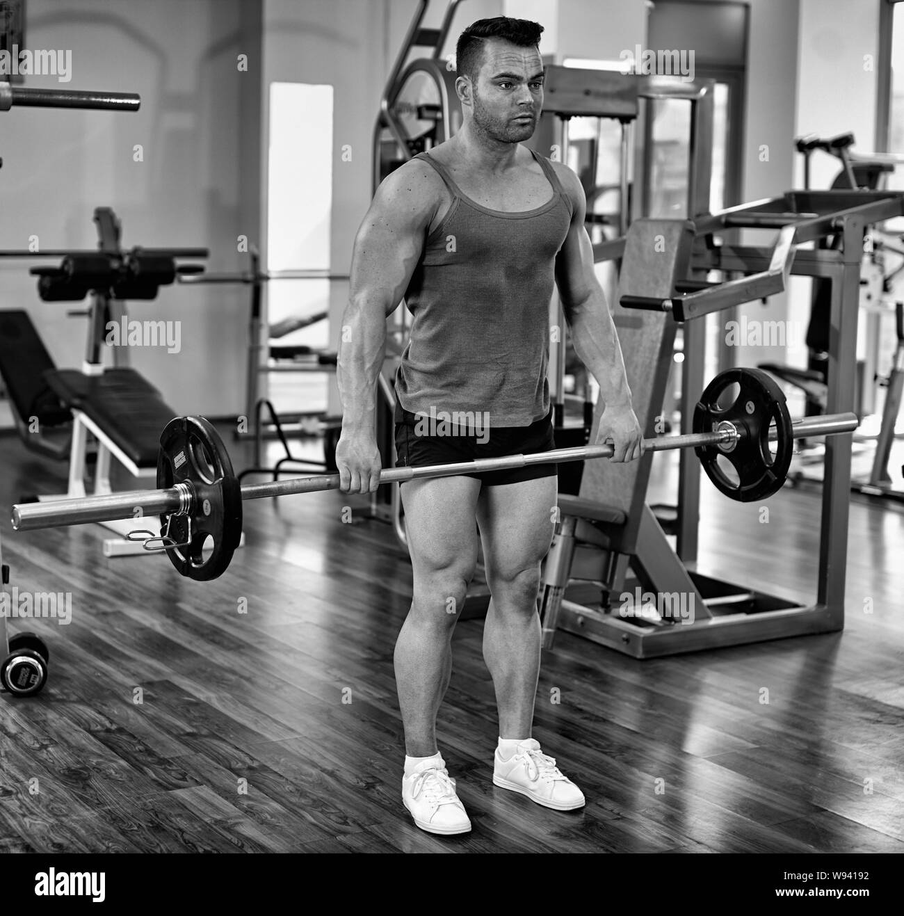 Man doing deadlifts with a barbell in a gym Stock Photo