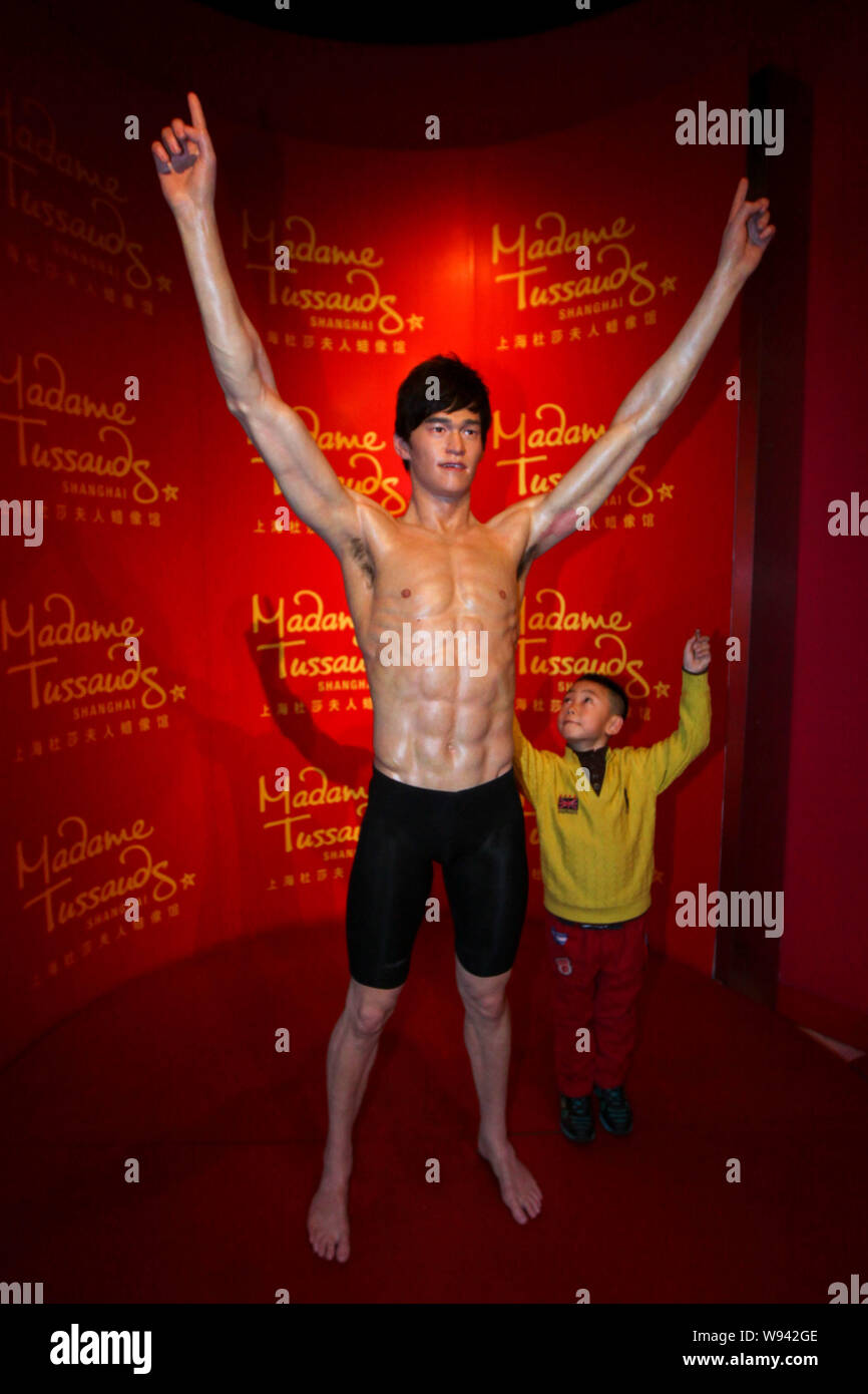 A boy poses with the wax statue of Chinese swimmer Sun Yang at Madame Tussauds Shanghai in Shanghai, China, 4 February 2013.   Chinese swimmer Sun Yan Stock Photo