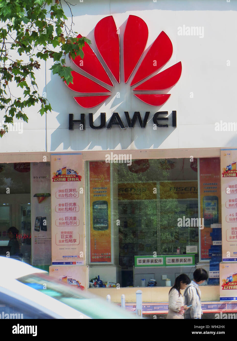 --FILE--Pedestrians walk past a store of Huawei in Yichang city, central Chinas Hubei province, 24 October 2013.   The Obama administration is private Stock Photo