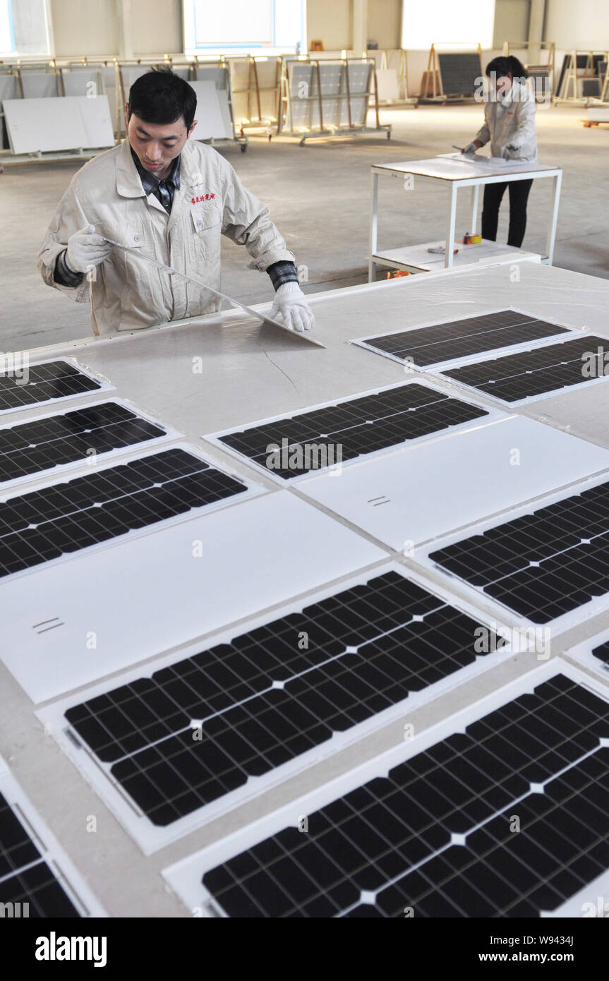 --FILE--Chinese workers examine solar panels at the factory of Shandong Hilight Solar Co., Ltd. in Zouping county, Binzhou city, east Chinas Shandong Stock Photo