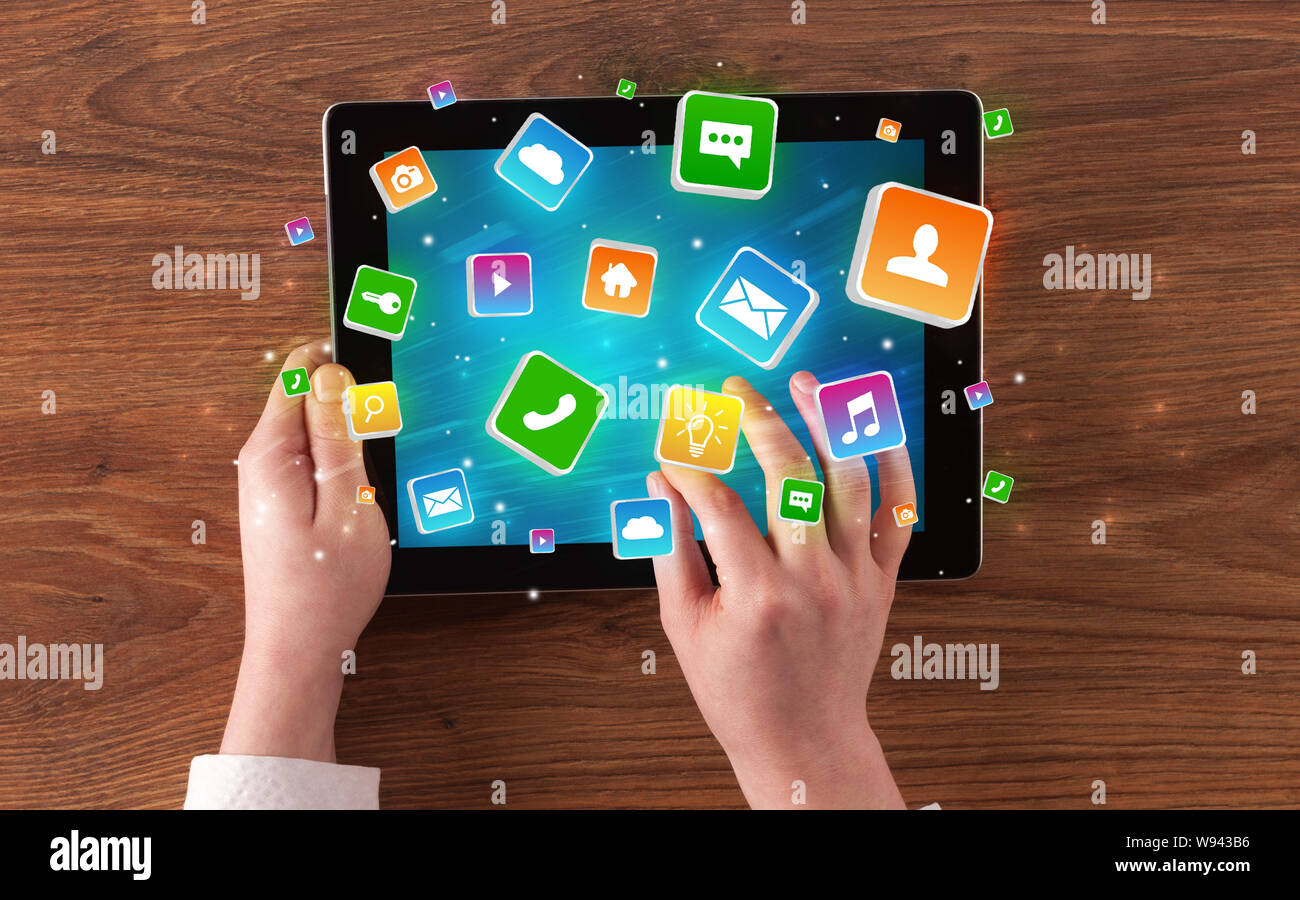 Hand using tablet with colourfull bounce application symbols and icons ...