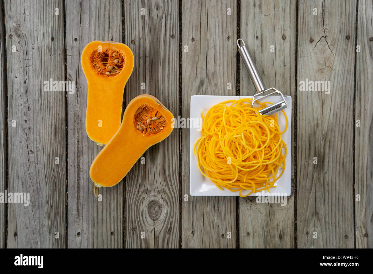 Female hands making butternut squash noodles with a vegetable peeler.Top  view Stock Photo - Alamy