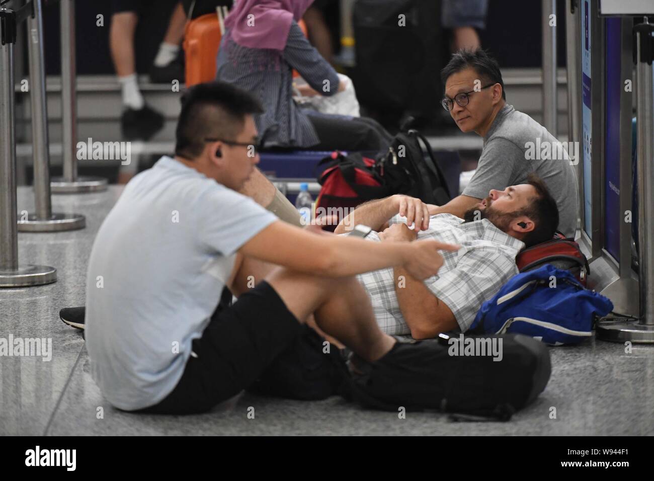 Hong Kong. 12th Aug, 2019. Stranded passengers are seen at Hong Kong International Airport in Hong Kong, south China, Aug. 12, 2019. All flights in and out of China's Hong Kong Special Administrative Region were cancelled on Monday due to a protest held in the Hong Kong International Airport, according to local airport authority. Credit: Lui Siu Wai/Xinhua/Alamy Live News Stock Photo