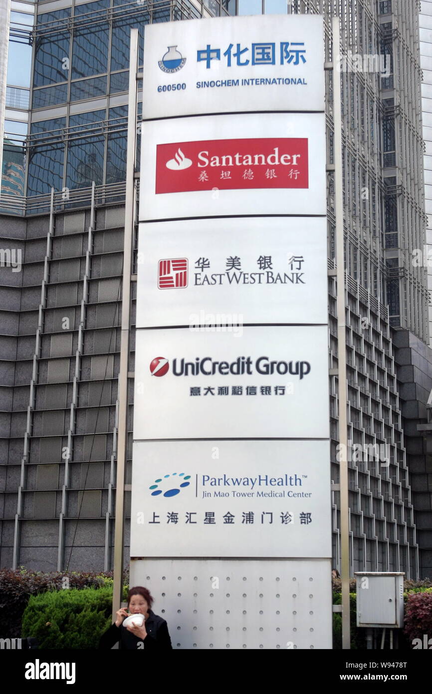 FILE--A Chinese woman eats in front of a signboard of Sinochem  International, Banco Santander, East West Bank, UniCredit Group and Medical  Center of Stock Photo - Alamy