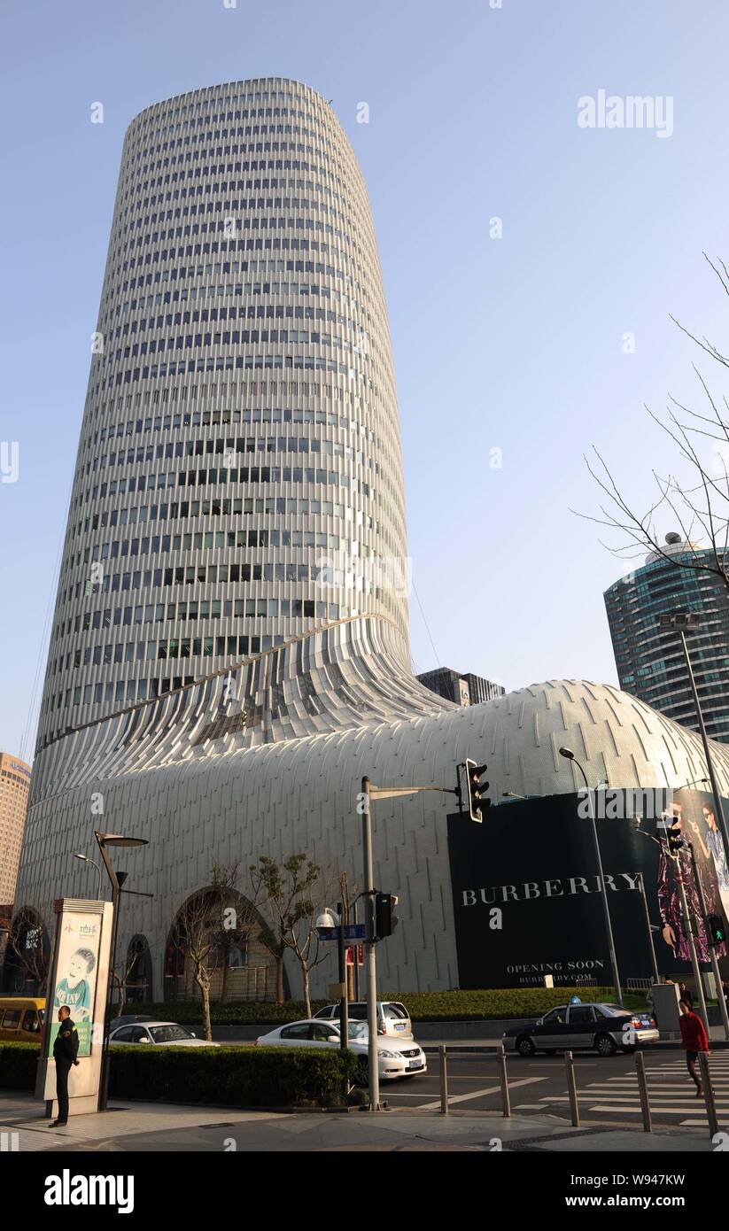 Pedestrians walk past the LAVENU Center, also known as Boot Tower, at Hongqiao in Shanghai, China, 14 March 2013.   The LAVENU Center under LVMH Group Stock Photo