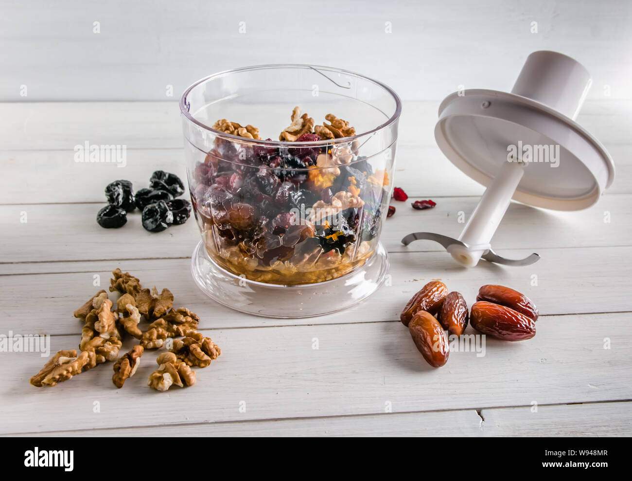 ingredients for energy balls in a blender on white background with copy