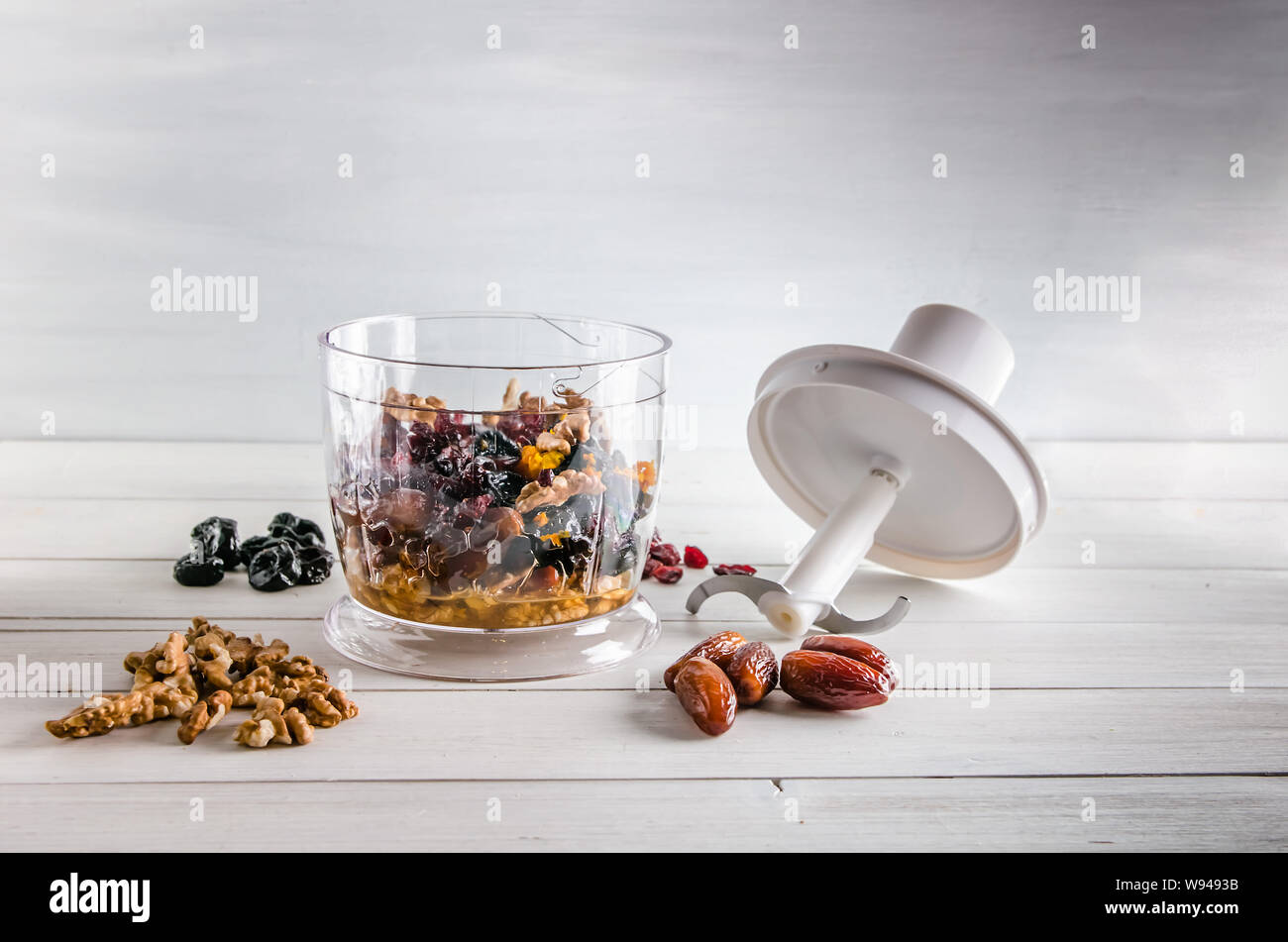 ingredients for energy balls in a blender on white background with copy