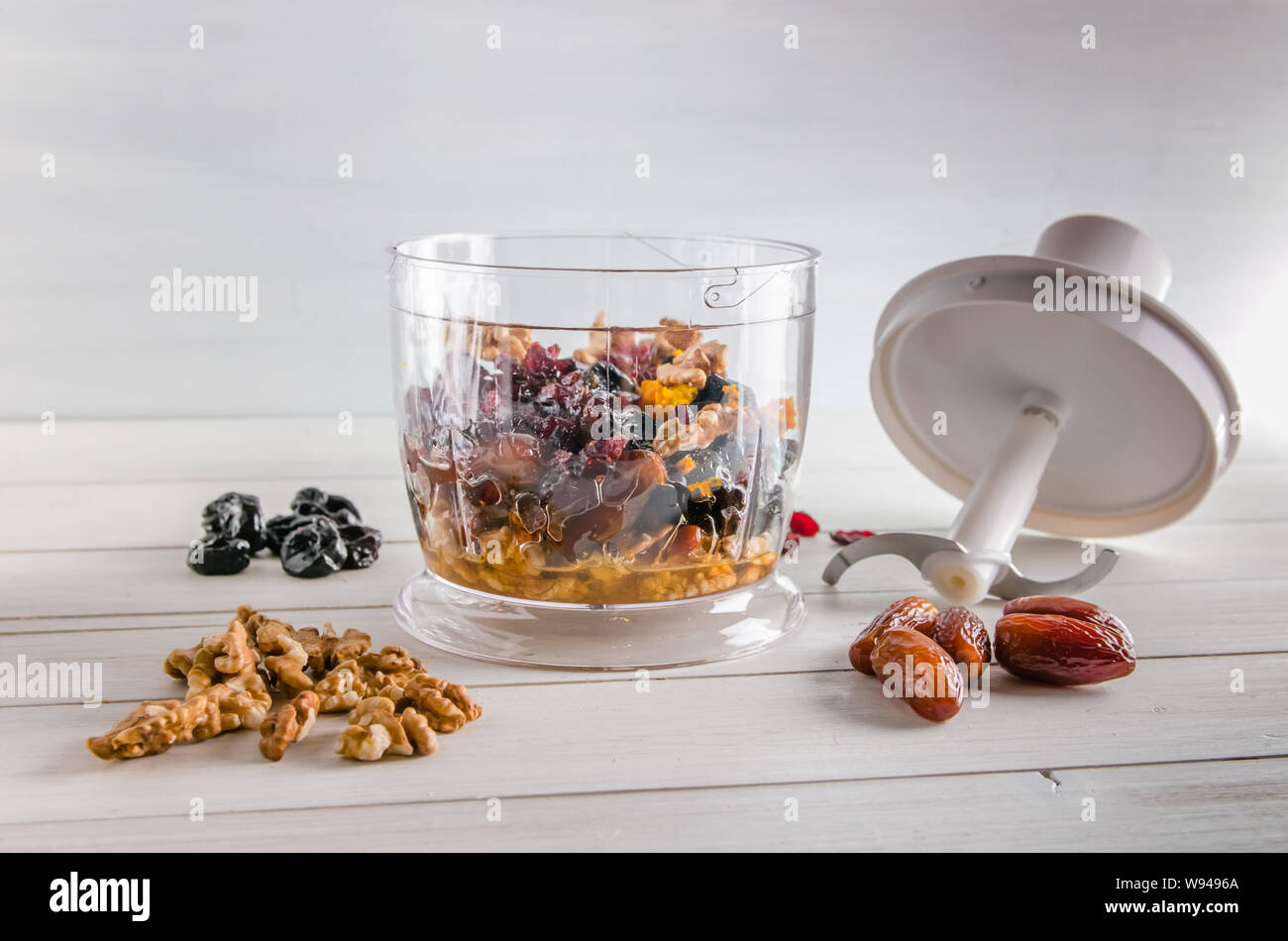 ingredients for energy balls in a blender on white background with copy
