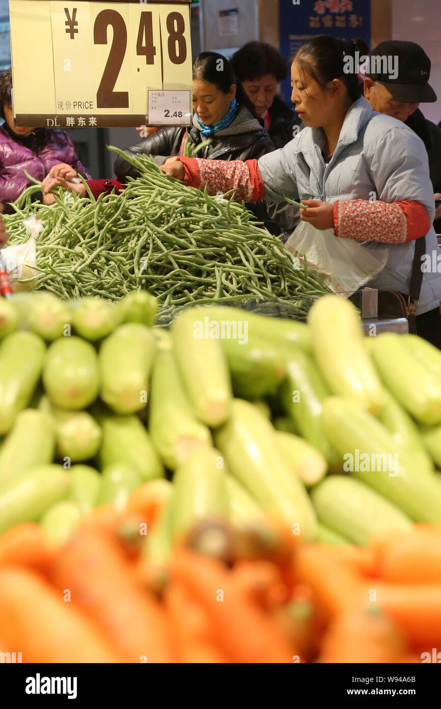 Chinese customers shop for vegetables at a supermarket in Xuchang city, central Chinas Henan province, 30 November 2013.   Chinas inflation decelerate Stock Photo
