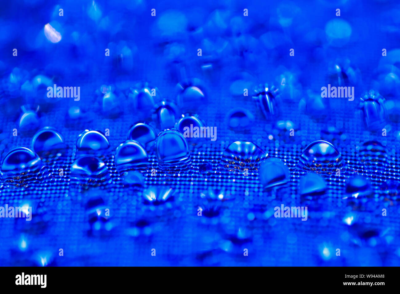 Water drops on the blue textured surface Stock Photo