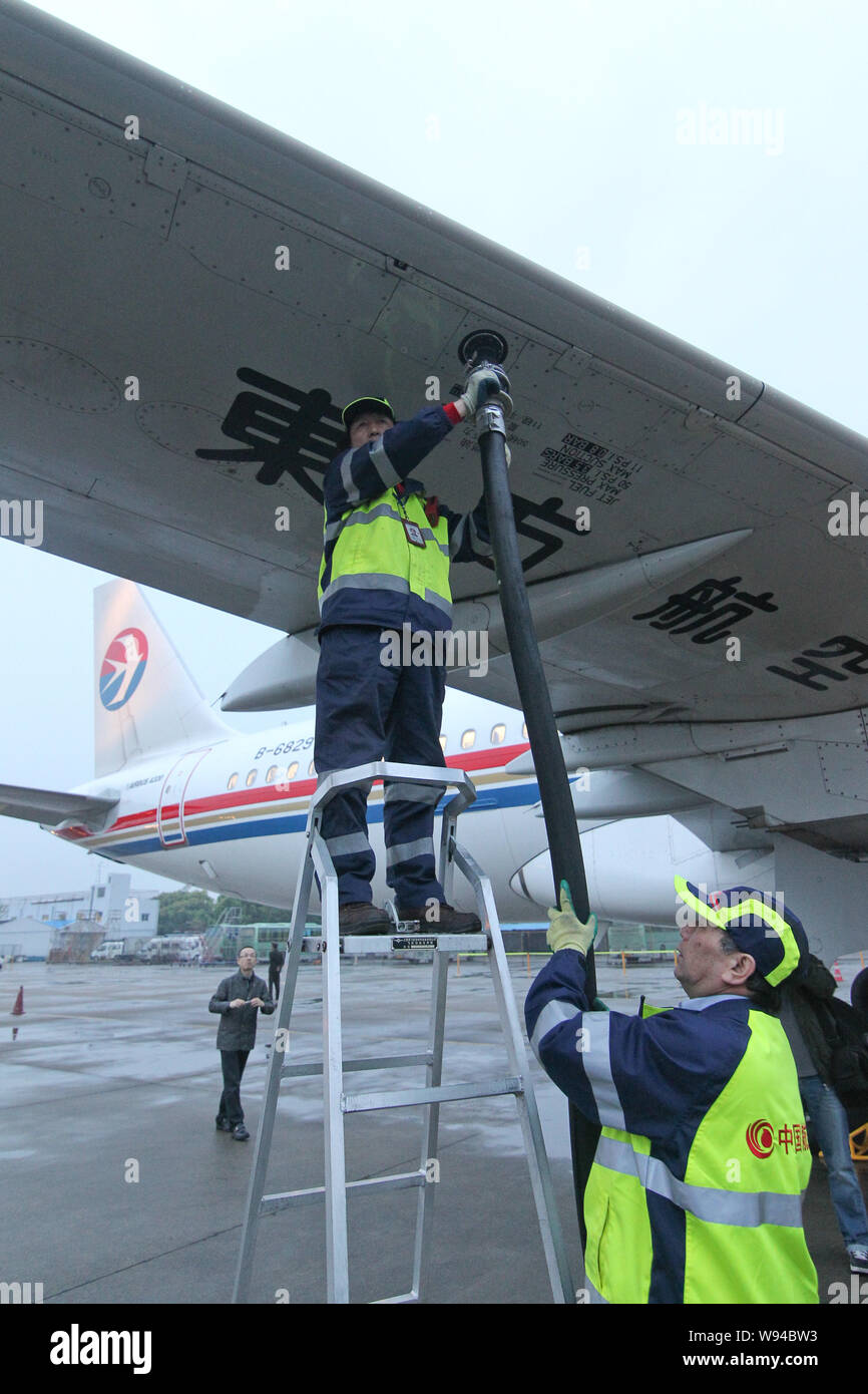 A Chinese ground crew member fuels an Airbus A320 jet plane of China Eastern Airlines with