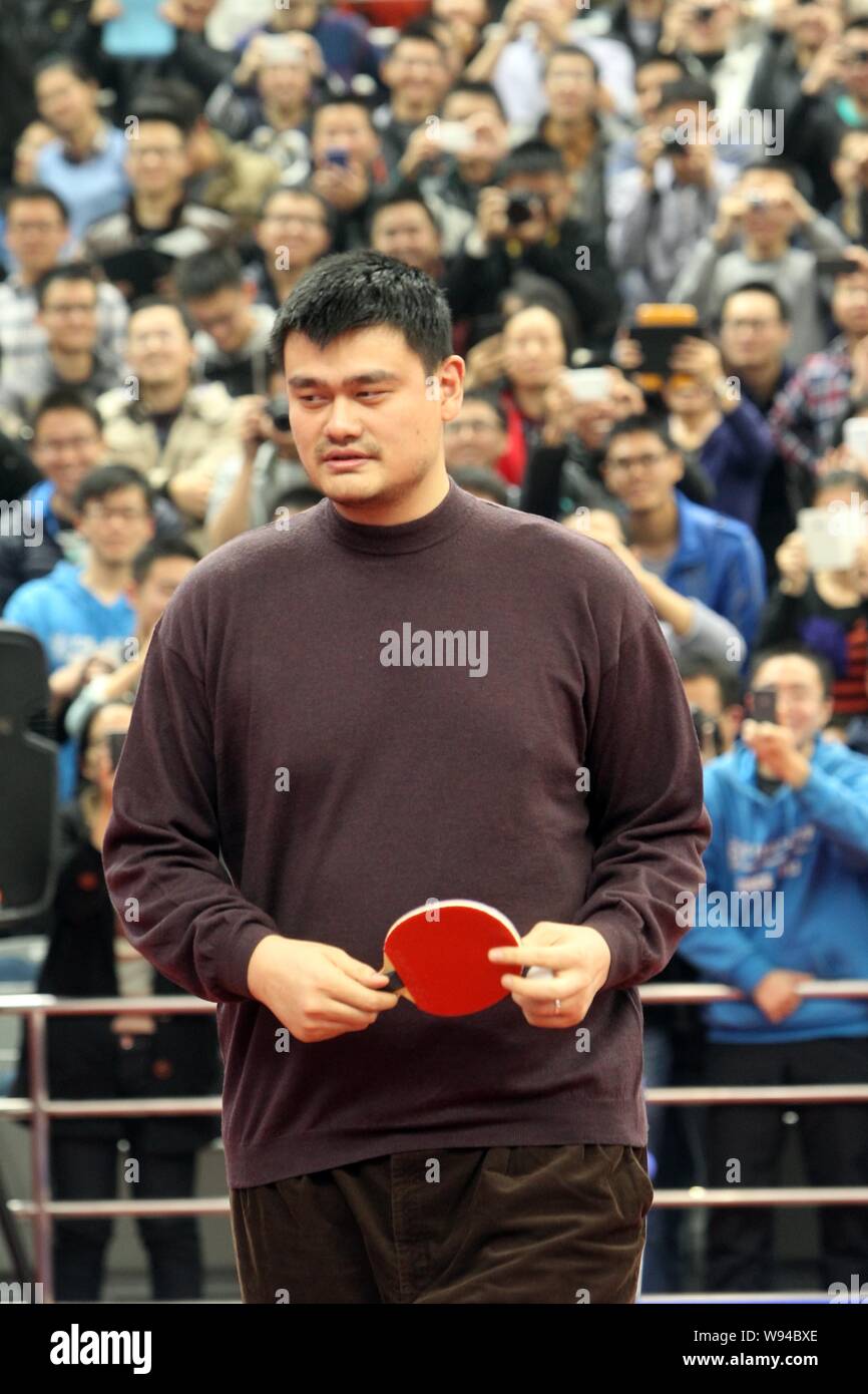 Former NBA basketball player Yao Ming is pictured holding a ping-pong bat while playing table tennis with Liu Guoliang, left, head coach of the Chinas Stock Photo