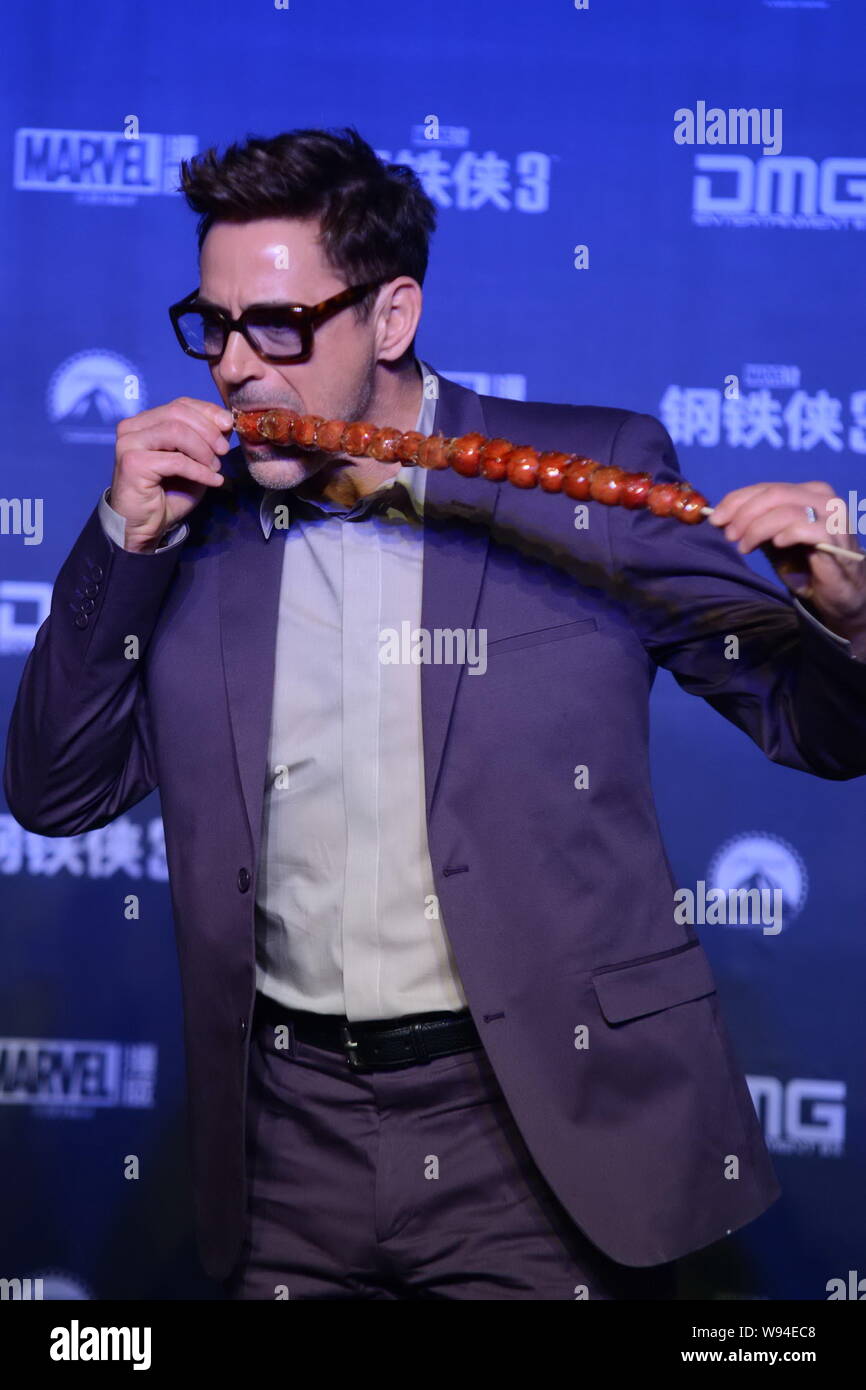 American actor Robert Downey Jr. has a bite of sugarcoated haws during a press conference for promoting his latest movie, Iron Man 3, in Beijing, Chin Stock Photo