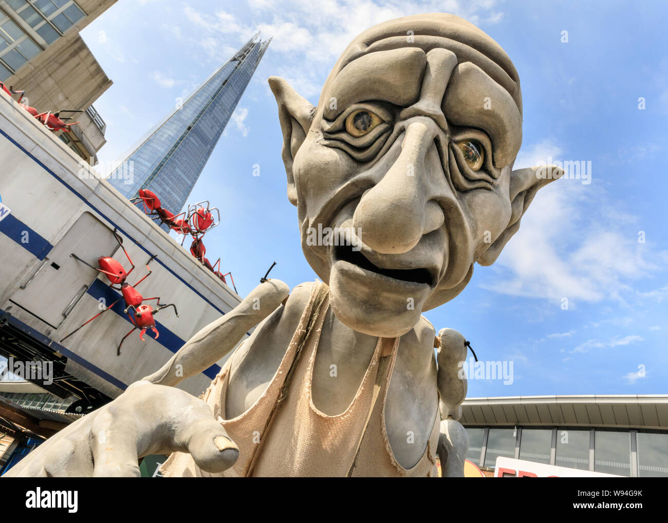 Gnomus, Caretaker of the Earth, a giant gentle green giant puppet by 'Puppets with Guts' puppeteers, performance outside near the Shard, London, UK Stock Photo