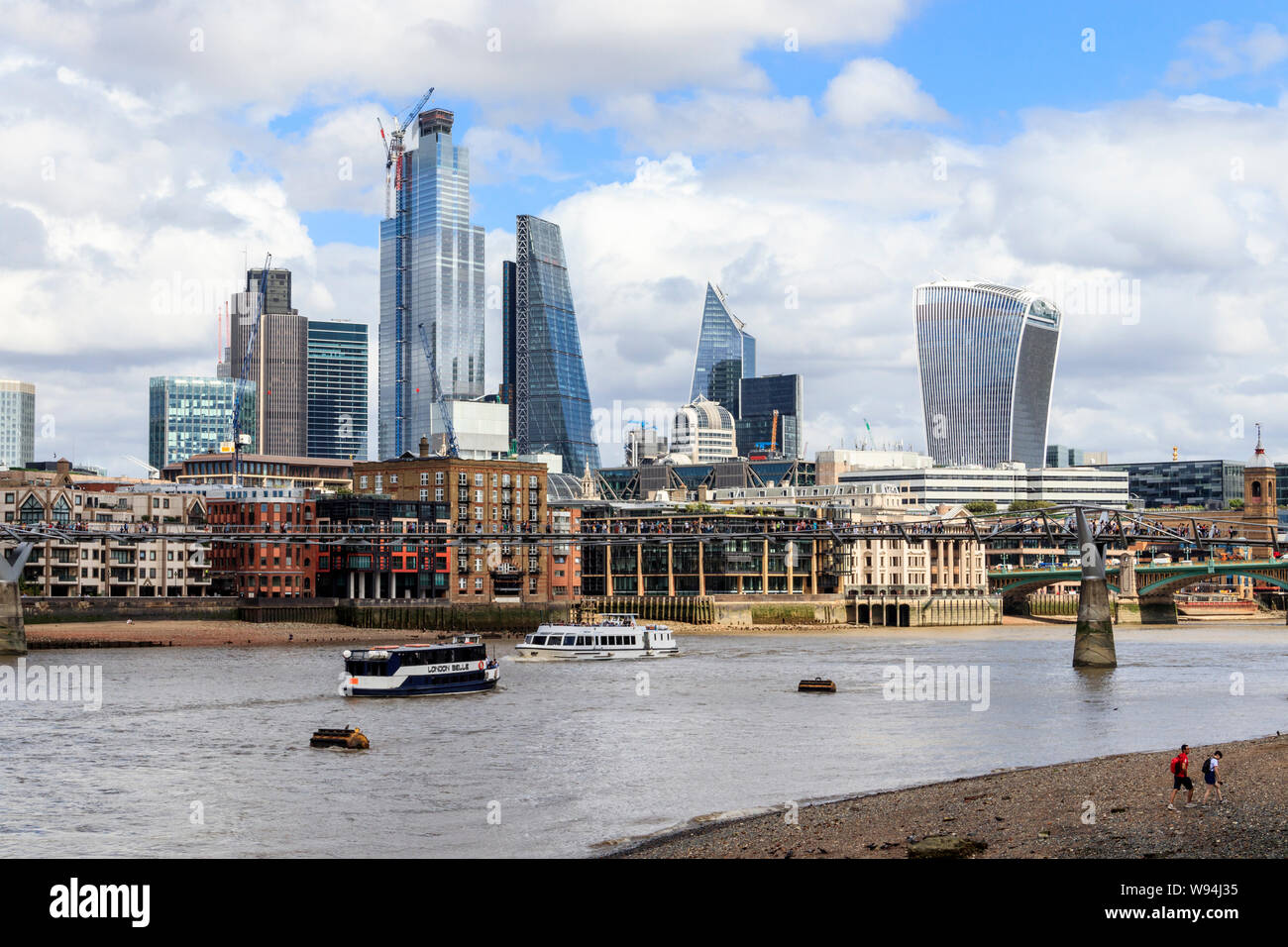 View of the City of London from the south bank of the River Thames at low tide, Bankside, London, UK Stock Photo