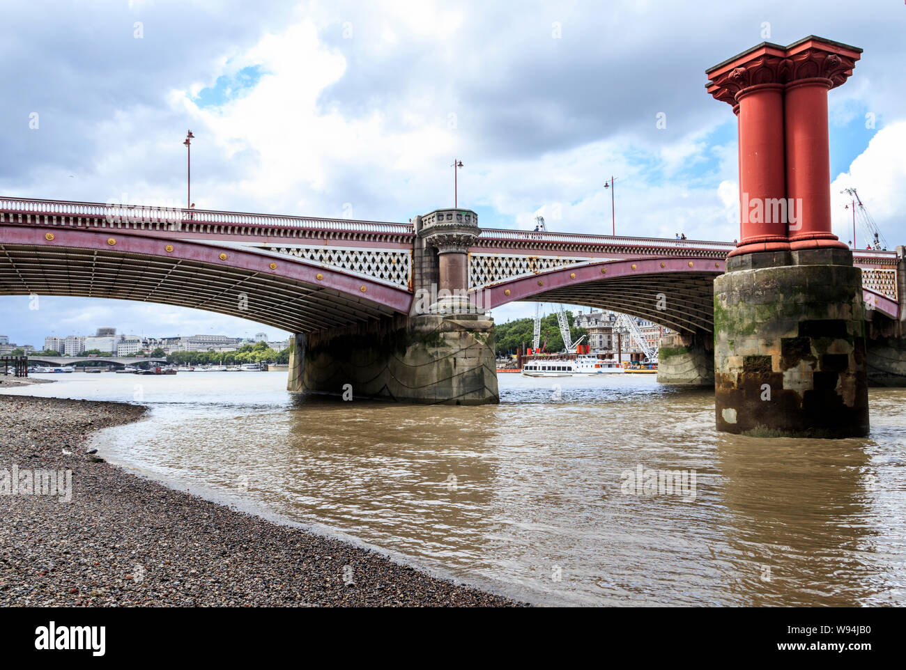 Blackfriars road bridge from the south shore of the River Thames at low tide, pillars of the old bridge on the right, London, UK Stock Photo