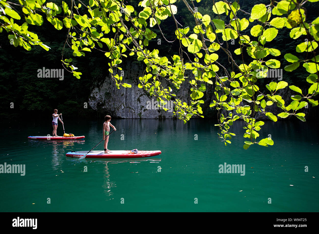 Mother and son having fun on stand up paddle  on the beautiful Idrijca river at Most na Soci, Slovenia Stock Photo