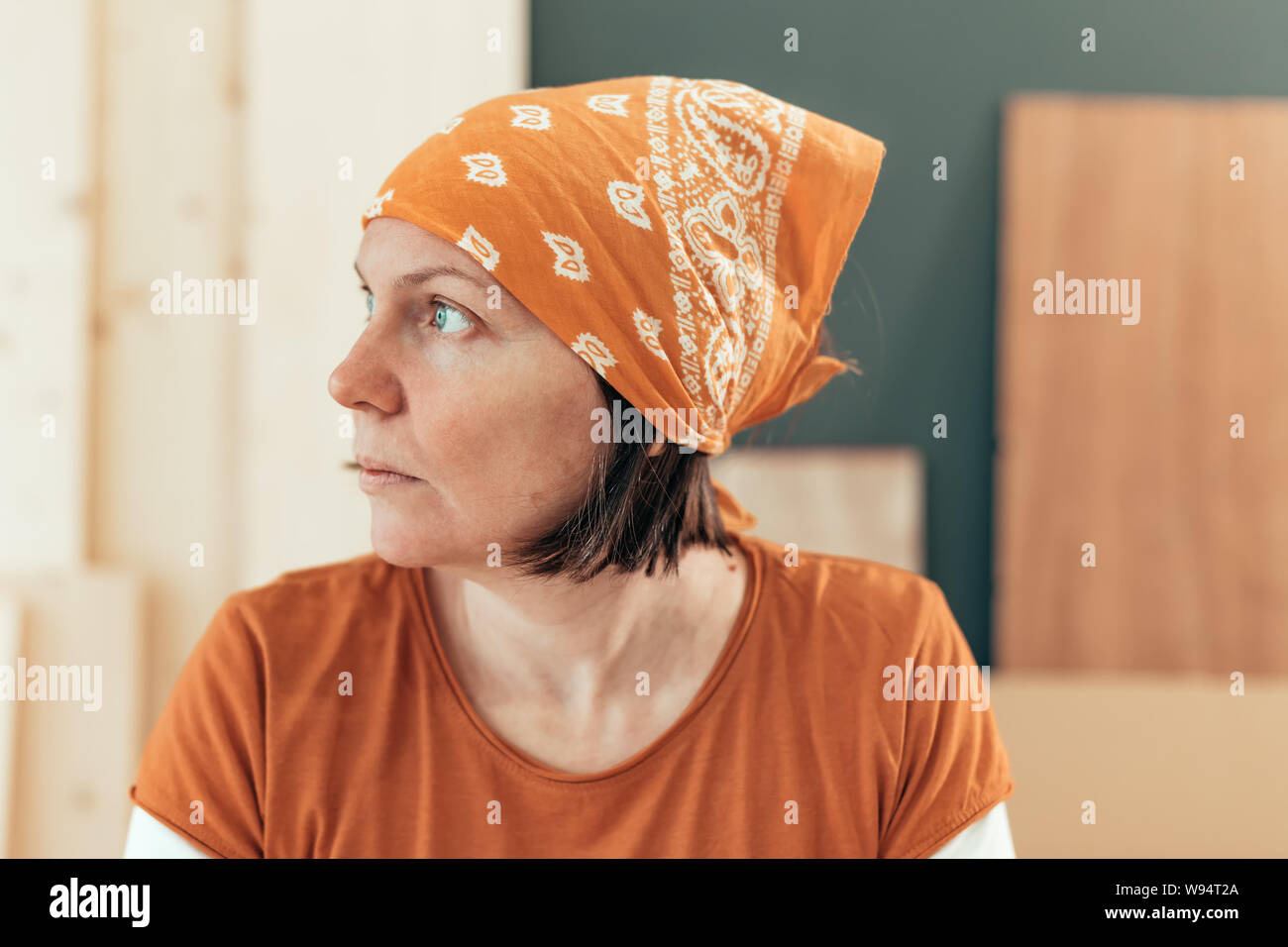 Self employed female carpenter looking out the window portrait in her small business woodwork workshop Stock Photo