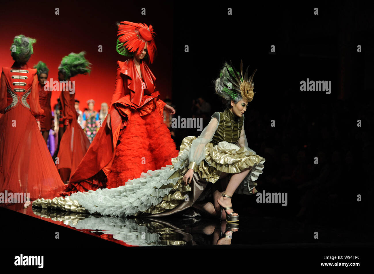 A model falls as she displays a new creation in the She Guang Hu