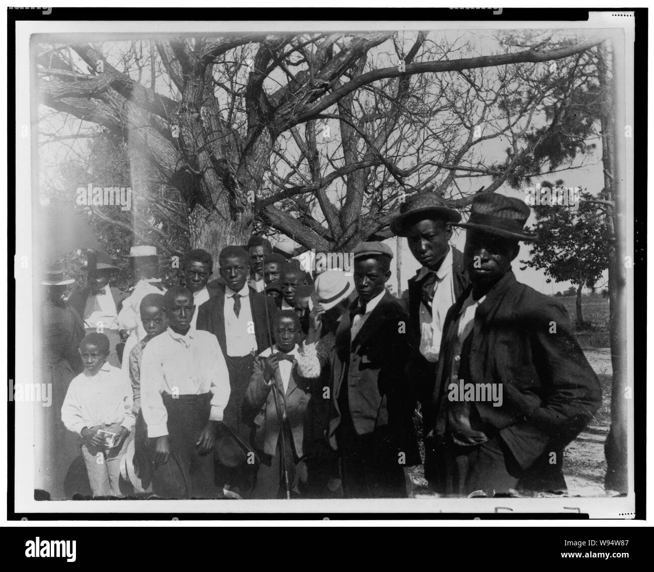 African American men and boys, three-quarter length portrait, dressed for church, trees in background Stock Photo