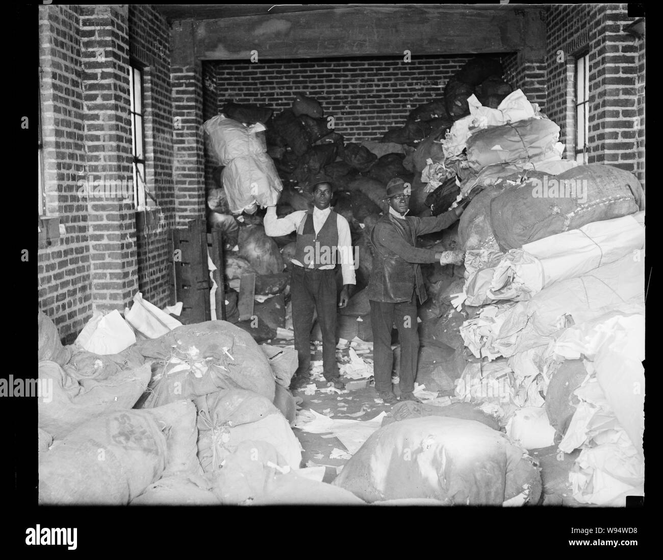 African American men handling large bags of paper Stock Photo