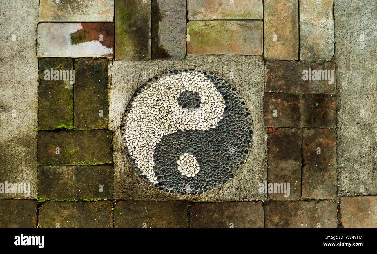 ying and yang sign on a weathered brick wall Stock Photo
