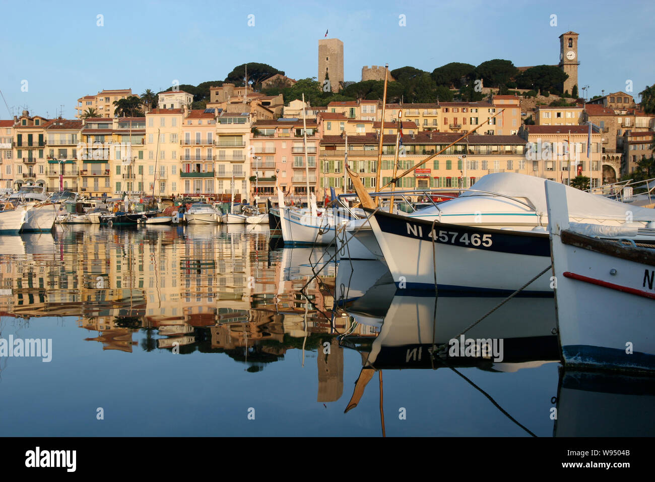 Cannes Port with fishing boats and view of Le Suquet Hill, Cannes France Stock Photo
