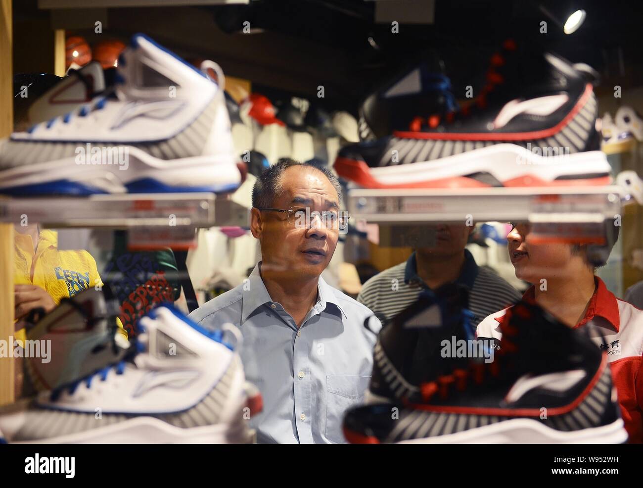 FILE--Former Olympic gymanstics champion Li Ning, chairman of Li Ning Co.,  looks at sports shoes for sale on the shelves as he visits the Li-Ning sp  Stock Photo - Alamy