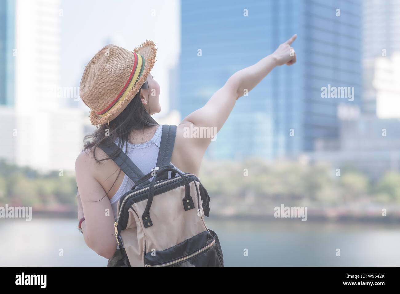 Beautiful asian solo tourist woman  smiling and searching for tourists sightseeing spot. Vacation travel in summer. Stock Photo