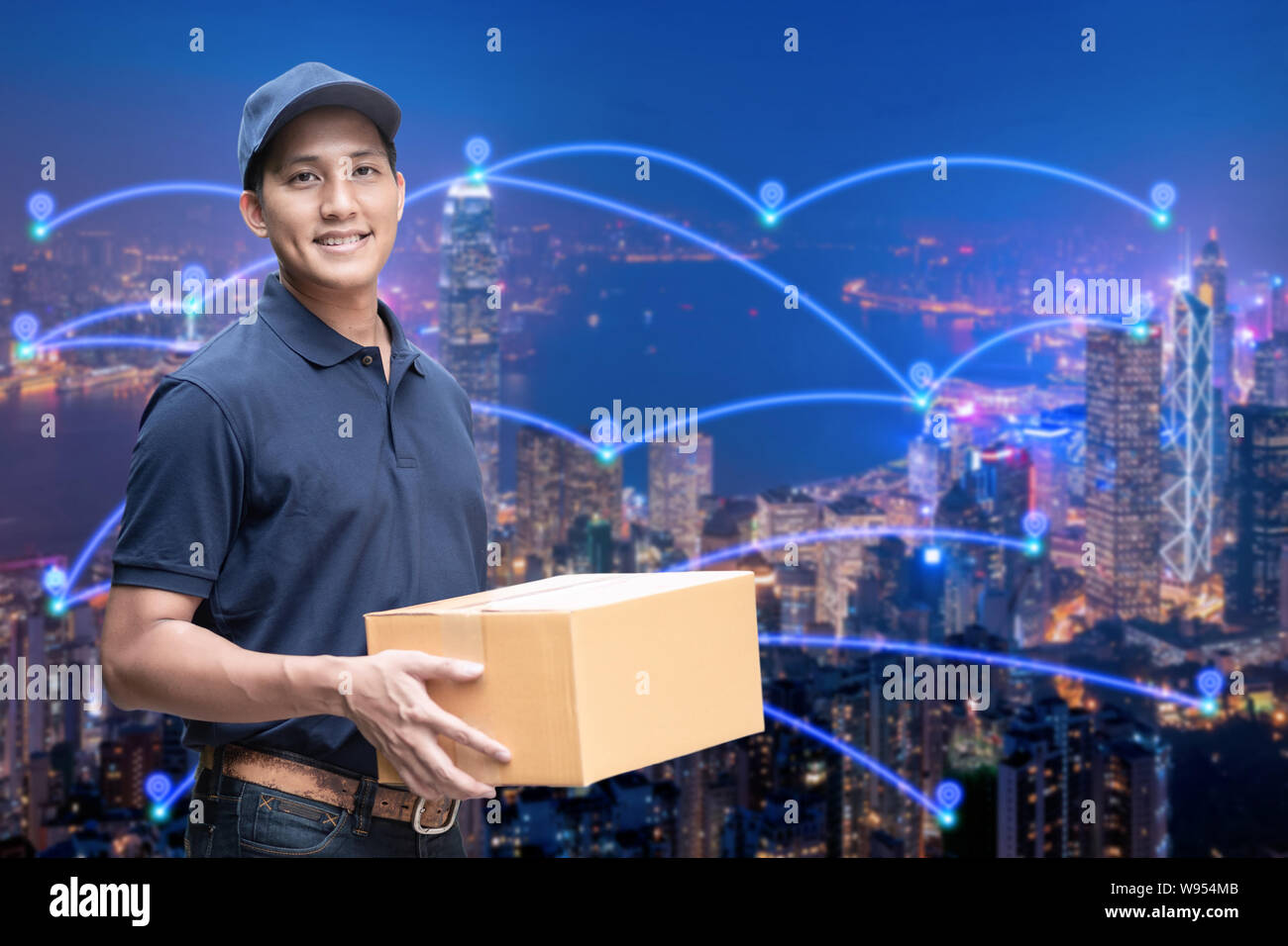 Asian delivery man holding a cardboard box with networking of internet of things in smart city for e-commerce and logistics concept. Stock Photo