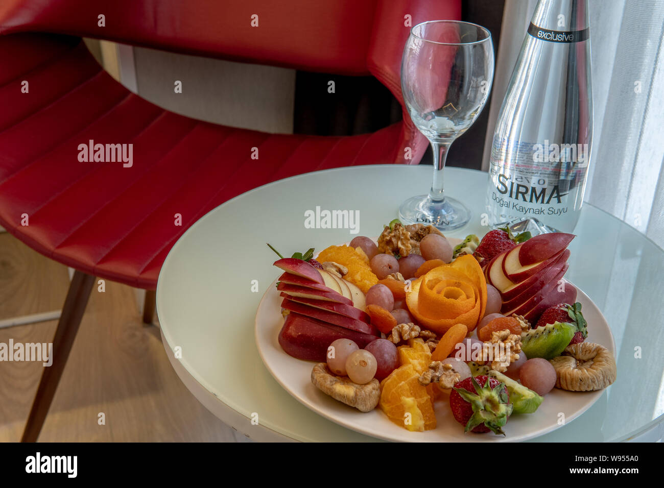 Fruit platter in hotel room with red chair in background Stock Photo