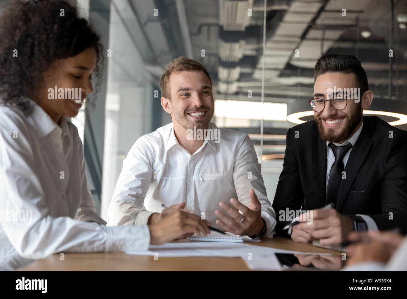 Smiling diverse colleagues having fun at business briefing in office Stock Photo