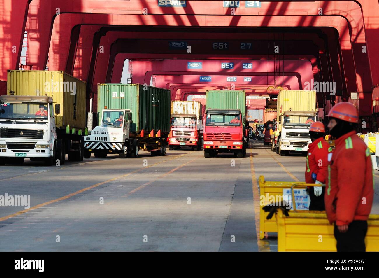 Vans and workers are seen at a container terminal in Qingdao, east Chinas Shandong province, 4 January 2012.   Chinas exports and imports grew at thei Stock Photo