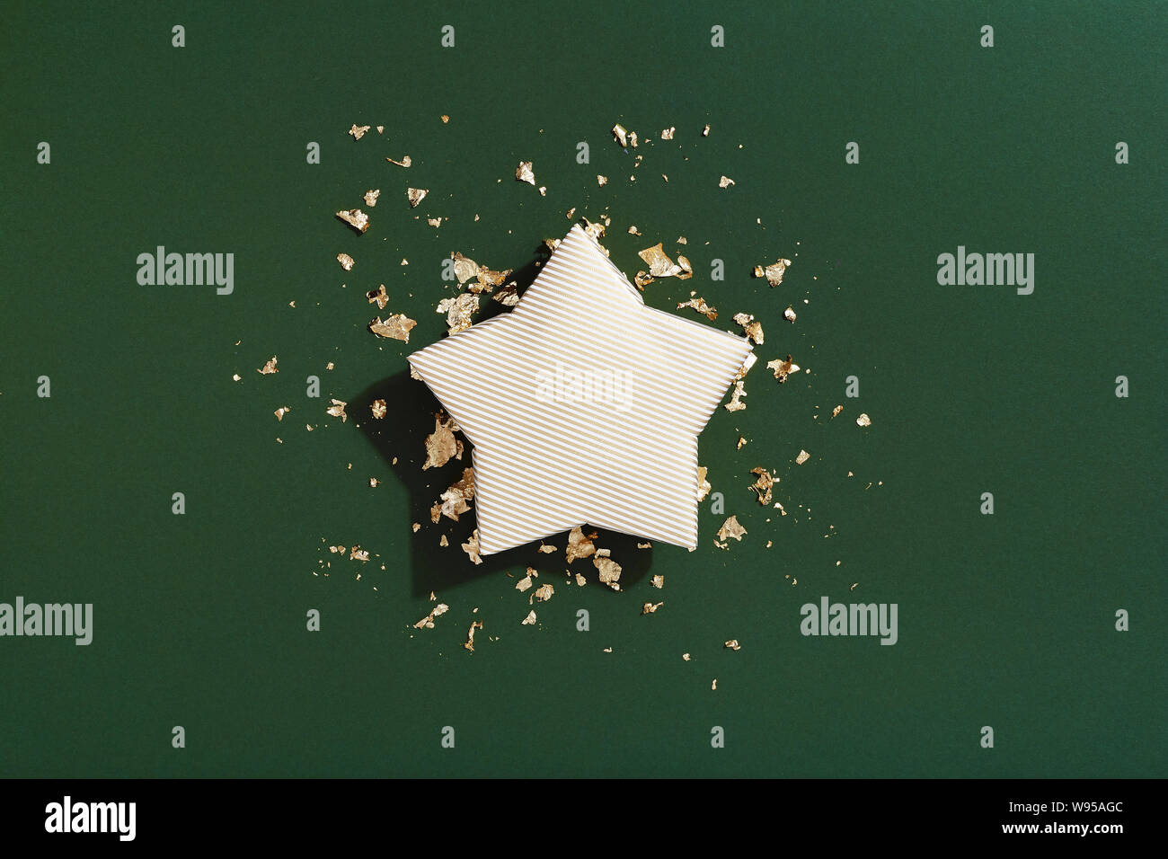 Christmas gift box, star shaped present on green background, celebration flat lay Stock Photo