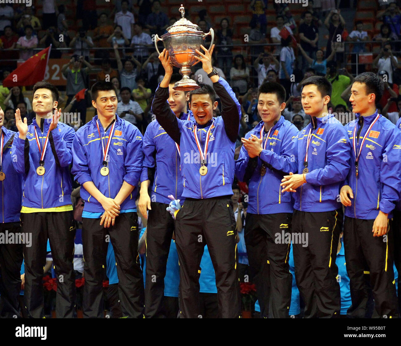 Lin Dan of China, center, holds up the Thomas champion trophy at the award ceremony after defeating South Korea during the final match of the Thomas C Stock Photo