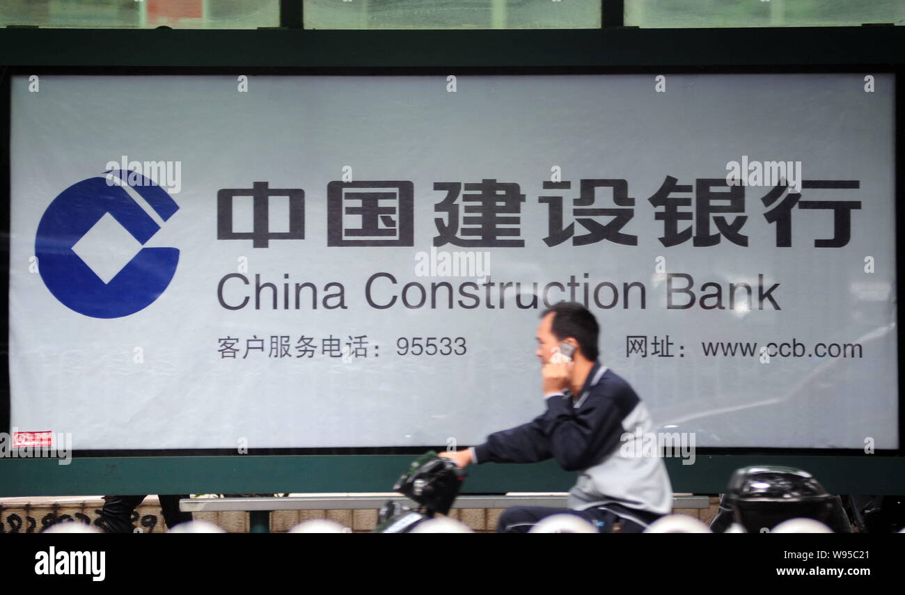 --File--A man drives past a billboard of China Construction Bank in Haikou city, south Chinas Hainan province, 13 December 2011.   Temasek Holdings Pt Stock Photo