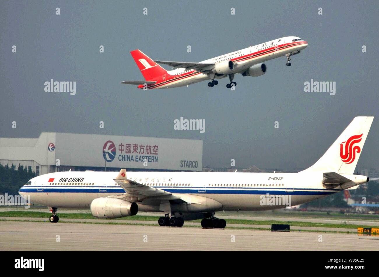 File An Airbus A330 300 Jet Plane Of Air China Front Moves To The Runway As A Boeing Plane Of Shanghai Airlines Takes Off At The Hongqiao Interna Stock Photo Alamy