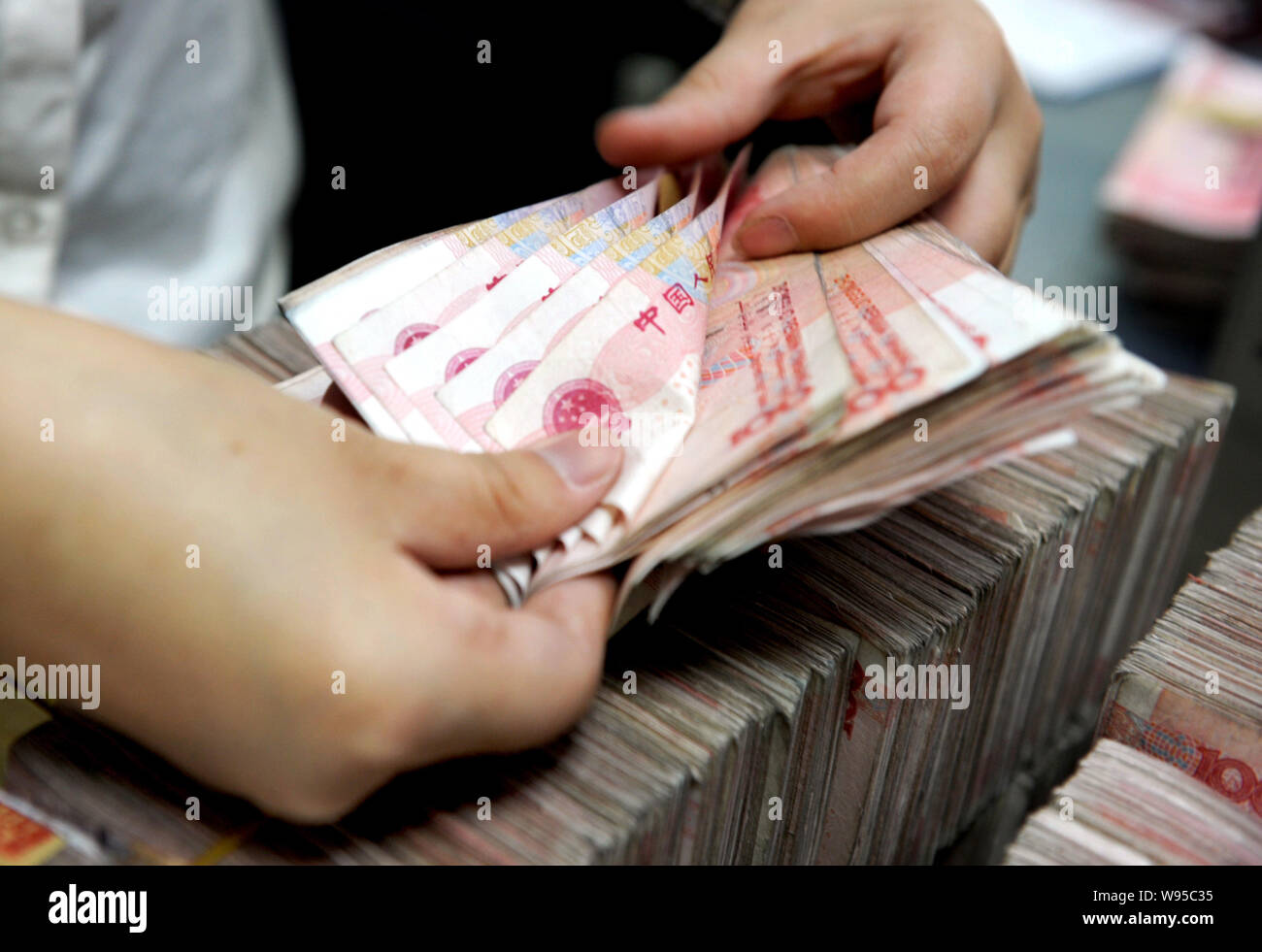 Counting Rmb --FILE--A Chinese clerk counts RMB (renminbi) yuan bills at a bank in ...